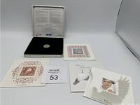 The coin is displayed in an official Millennium keepsake tin with four individual Canadian collectible stamps on decorative presentation cards surrounding it.