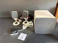 Two Dell AY410 satellite speakers, subwoofer and wired volume control knob on black surface.