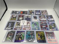 Overview of 22 football cards laid out on white background. Cards display various types including jersey patches and autographs across multiple brands.