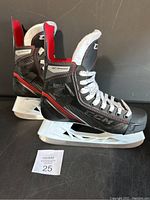 Pair of black CCM JetSpeed FT455 hockey skates with red and white detailing, displayed side by side on a black surface with white blades and laces.
