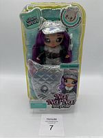 Front view of Na! Na! Na! Surprise Glam Series Chrissy Diamond doll in original packaging with silver cap and purple hair showing fish-shaped glitter bag accessory.