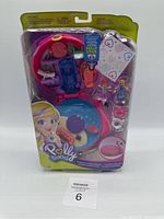 Front view of Polly Pocket Flamingo Floatie Compact in sealed packaging showing included accessories and figures