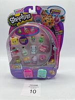 Front view of Shopkins Season 5 12-pack with 2 bonus charms in packaging showing all figures