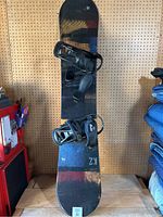 Full view of the K2 snowboard with Burton bindings attached, showing the board's design and setup.