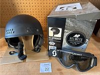 K2 snowboard helmet on cardboard with Scott snow goggles in front and K2 helmet box behind them.