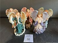 Front view showing all seven angel figurines grouped together to display poses and color palette.