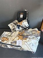 Image of folded Yukon Gear camouflage overalls showing the pattern and size tag