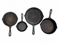 Top view of the four Finlay cast iron pans arranged side by side showing various sizes from small to large with characteristic handles and pouring spouts.