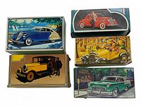 Five Avon after shave bottles displayed with original boxes, with vintage car themed artwork.