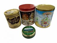 Four tins: three large decorative tins including Charles Chips, Christmas themed, and a small green Walkers tin.