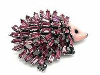 Front angle showing purple rhinestone crystals as spines, pink enamel face, silver-tone setting