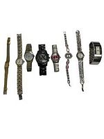 Top-down view of 8 assorted wristwatches laid out in a row showing variety in band style, face size, and color.