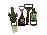 Photo showing four assorted vintage-style metal bottle openers including a brass eagle motif, an Exeter emblem opener, a large rustic opener, and a Carlsberg bottle-shaped opener