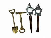 Four assorted bottle openers including shovel, hammer with engraving, and two metal with wooden handles
