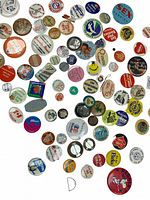 Photo showing a spread of assorted vintage buttons with various slogans and images, mostly round and colorful, some metallic.
