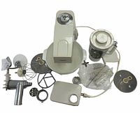 Kenwood food mixer base with large mixing bowl, blender attachment, meat grinder, various beaters, dough hooks, and bowl cover arranged on a flat surface.