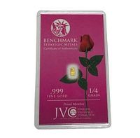 Gold bar and certificate encased in plastic showing .999 fine gold and 1/4 grain weight with Benchmark branding and a rose image