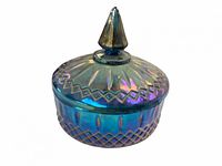Blue iridescent glass candy holder with lid on, showing decorative geometric and petal designs and pointed finial.
