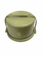 Green Tupperware cake carrier with dome lid, handle, and flower emblem