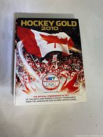 Front cover of the English version DVD case showing Canadian hockey fans waving a large Canadian flag with Vancouver 2010 Olympic logo and event title.