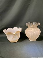 Front view of two vintage lamp shades showing white milk glass floral design and clear textured glass shade