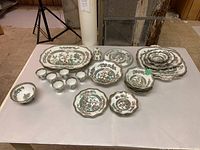 Full set of serving pieces on table: platter, compote, serving bowls, nut bowls, plates and egg cups