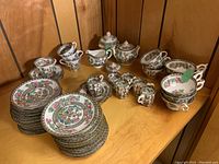All the tea and coffee cups, saucers, sugar bowls and creamers arranged on a table showing variety and quantity.
