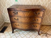 Front view of the wooden hallway chest showing the three drawers and brass handles with visible wood grain patterns.