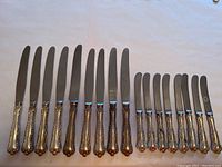 Full set of 17 knives laid out—9 longer dinner knives at left, 8 shorter butter knives at right