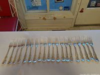 Full set of twenty forks arranged side by side on table