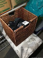 Photo of woven basket with gloves inside, showing basket texture and some glove pairs at top