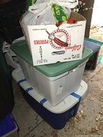 Photo of the stacked totes and white box containing Christmas decorations