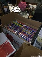 Box showing multiple VHS tapes packed inside with visible titles and purple Disney branding.