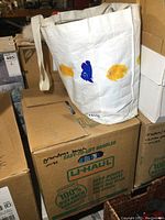 White tote bag with fish designs holding DVDs, BluRay discs, and CDs