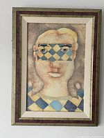 Full framed print of stylized face with diamond pattern, in vintage frame.