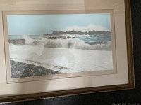Frontal view of the framed photographic print depicting waves crashing on shore with Partridge Island and Breakwater in the background, signed by artist F E Garrett.