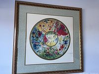 Framed artwork showing Marc Chagall's circular, colorful print with signature lower right and ornate frame.