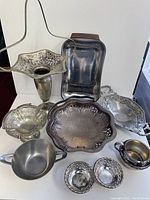 Overview of mixed metal vases, trays, and bowls with various ornamental patterns and shapes