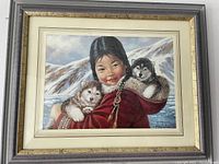Framed print of the girl holding two husky puppies in winter landscape