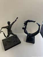 Two composite sculptures placed side by side on a flat surface against neutral background, clearly showing size and form of figures.