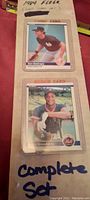 Close-up photo of Don Mattingly and Darryl Strawberry rookie cards in protective sleeves with handwritten label indicating 1984 Fleer 660 cards complete set.