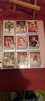 View of nine WHA hockey cards in protective sleeves showing various player images including Gordie Howe and Bob Bourne.