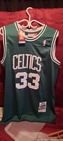 Front view of Larry Bird Boston Celtics basketball jersey with tags, showing Celtics name and number 33.