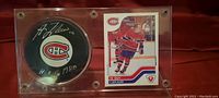 Front of display case showing the signed hockey puck and Guy Lafleur trading card.