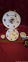 Complete child's breakfast set including large plate, small plate, cup, and mug all decorated with whimsical child and nature illustrations