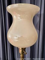 Close-up of the frosted white glass hurricane-style shade showing its shape and good condition.