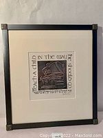Framed wall art titled "Teach a Child" with embossed design featuring a book and plant, black frame with metal corner details, 17"x19".