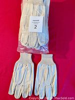 Photo of three pairs of heavy canvas work gloves, two pairs unpackaged, one pair in original plastic packaging. Gloves are beige with knitted wrist cuffs.