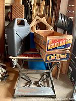 Wide view of Work Horse step stool, black gas can, and two wooden crates with vintage labels.