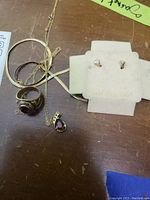 Group shot showing earrings on 14kt gold card, class ring, garnet pendant on chain, two gold chains